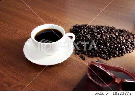 Coffee in white cup and a seed,book,Eyeglasses is placed nearby. 18823878