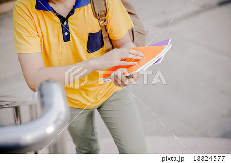young college student reading book on stairs young college student reading book on stairs 18824577