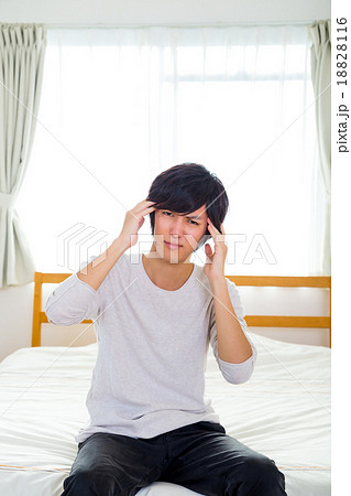 頭痛　二日酔い　疲れ　疲労　うんざり　体調不良　10代か20代の若い男性　ポートレート　部屋着 18828116