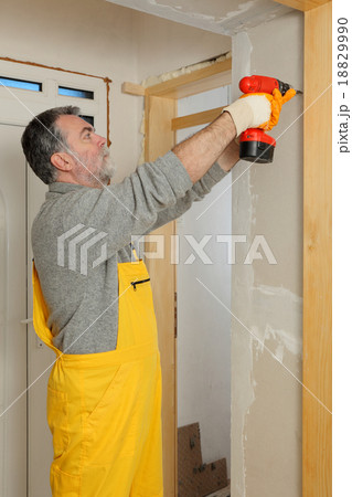 Construction site, worker installing gypsum board 18829990