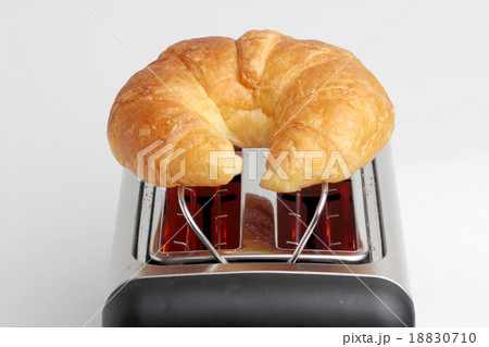 one croissant on red hot toaster 18830710