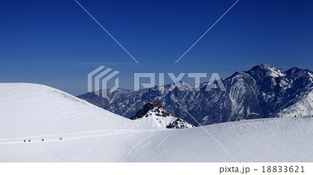 Snowboarders move on footpath to off piste slope  18833621