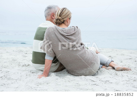 Cute couple sitting in the sand Cute couple sitting in the sand 18835852