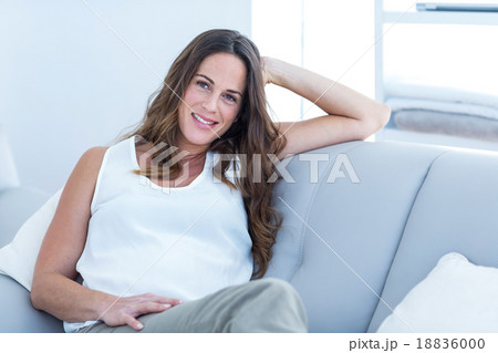 Happy pregnant woman sitting on sofa 18836000