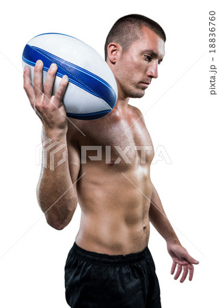 Confident shirtless rugby player holding ball 18836760