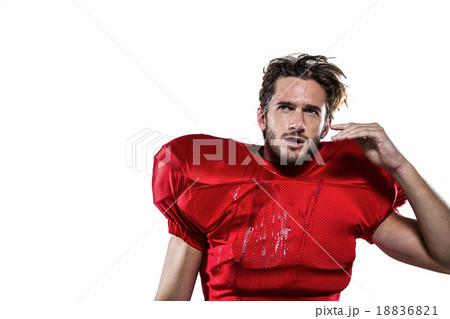 Wet American football player in red jersey looking away Wet American football player in red jersey looking away 18836821