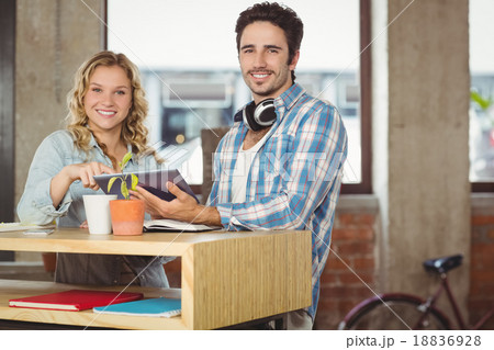 Happy business people holding digital tablet by table in office 18836928