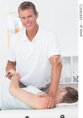 Doctor stretching a young woman back Doctor stretching a young woman back 18836971