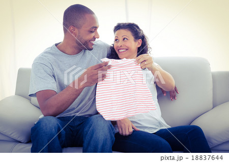 Cheerful couple with baby clothing 18837644