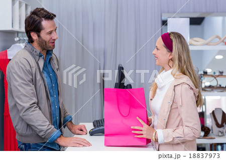 Smiling woman talking to cashier Smiling woman talking to cashier 18837973
