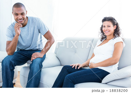 Portrait of couple sitting on sofa 18838200