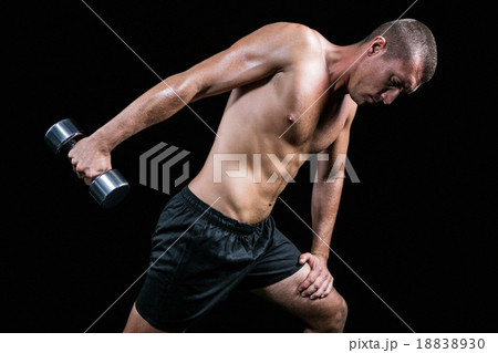 Shirtless athlete working out with dumbbell 18838930