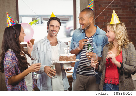 Portrait of smiling businessman holding cake during birthday cel 18839010