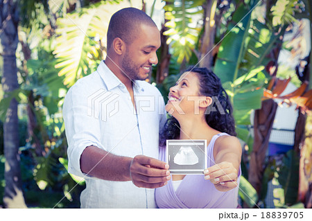 Happy man with pregnant wife holding sonogram 18839705