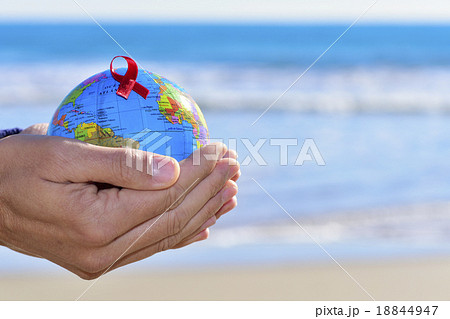 young man with a world globe with a red ribbon 18844947