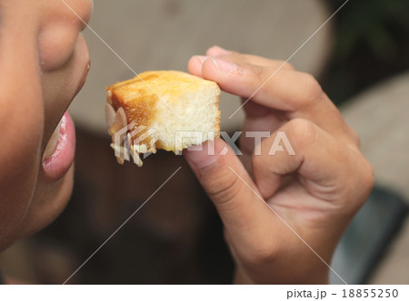 The boy eating toast topped with almonds 18855250