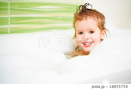 happy child girl bathes in  bath with foam and bubbles 18855759
