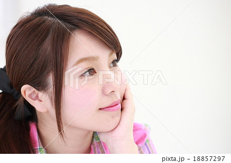 考え事をする若い女性の顔アップ 普通顔 の写真素材