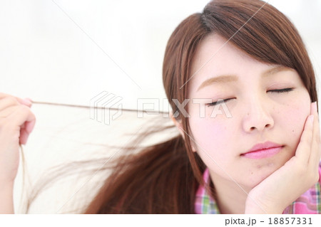 頬杖をする若い女性の顔アップ 目を閉じる の写真素材