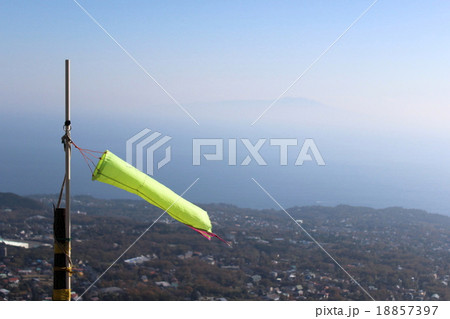 海を背にしてたなびくパラグライダー用の吹き流し 18857397