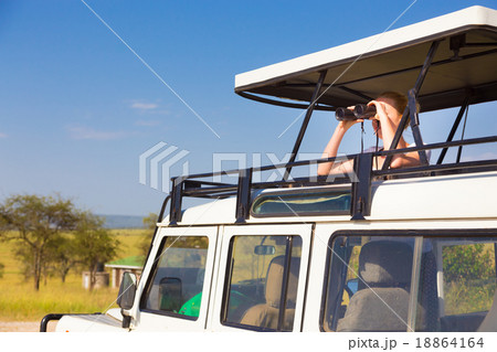 Woman on safari looking through binoculars. 18864164