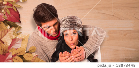 Composite image of young couple blowing over hands Composite image of young couple blowing over hands 18873448
