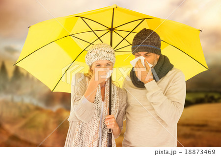 Composite image of couple sneezing in tissue while standing unde 18873469