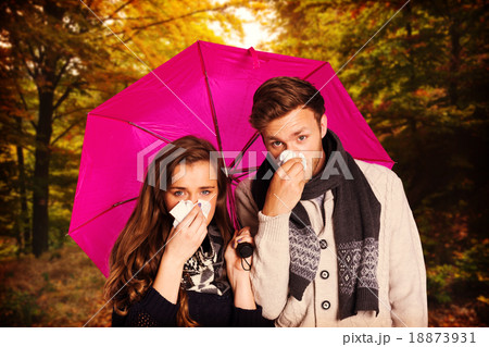 Composite image of couple blowing nose while holding umbrella 18873931