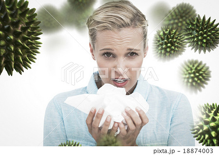 Composite image of blonde sick woman holding lots of tissues 18874003