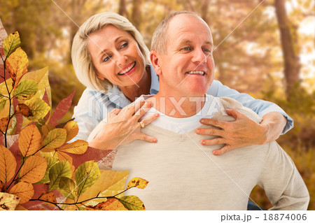 Composite image of happy mature man giving piggy back to partner 18874006