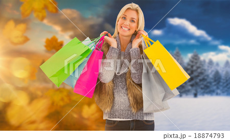 Composite image of blonde in winter clothes holding shopping bag Composite image of blonde in winter clothes holding shopping bag 18874793