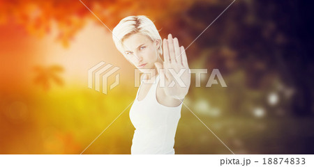 Composite image of angry pretty blonde showing her hand 18874833