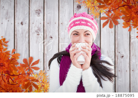 Composite image of winter brunette with coffee 18875095