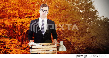 Composite image of sad geeky businessman holding box of his thin Composite image of sad geeky businessman holding box of his thin 18875202