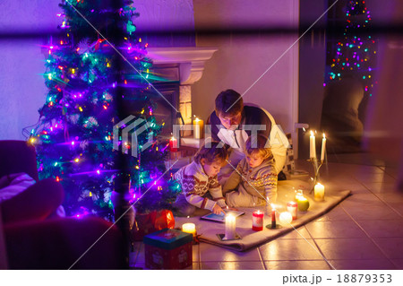 Young father and his little children sitting by a Young father and his little children sitting by a 18879353