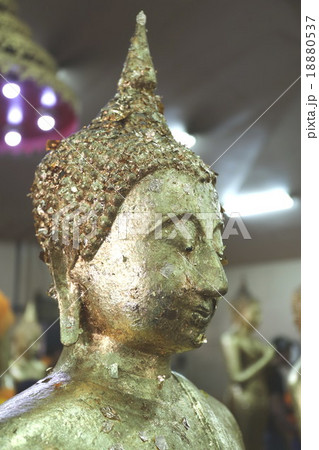 Buddha's face patched with gold sheet Buddha's face patched with gold sheet 18880537