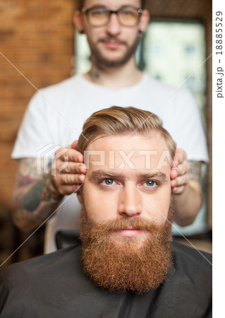 Skillful male barber is serving his client Skillful male barber is serving his client 18885529