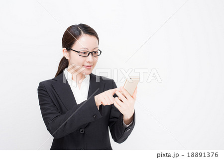スーツ　女性　メガネ　スマートフォン 18891376