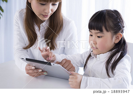 タブレットpcを操作する親子 18893947