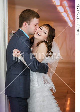 groom and the bride  stand near a white column 18895619
