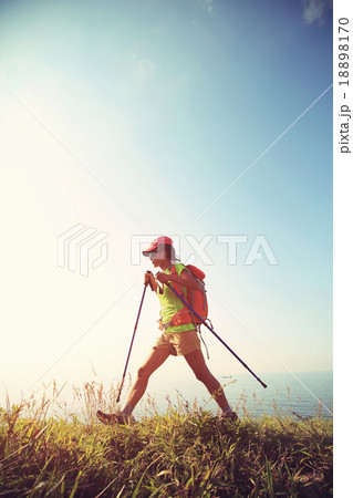 young woman hiker hiking on seaside mountain trail young woman hiker hiking on seaside mountain trail 18898170