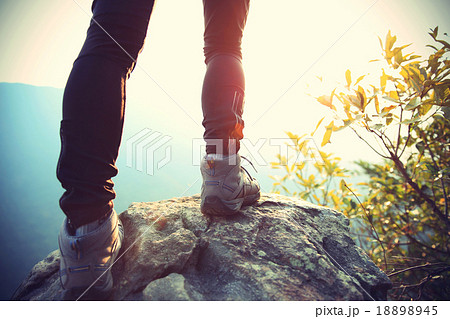 woman hiker legs on mountain peak rock woman hiker legs on mountain peak rock 18898945