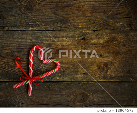 Candy canes in the heart shape on wood background Candy canes in the heart shape on wood background 18904572