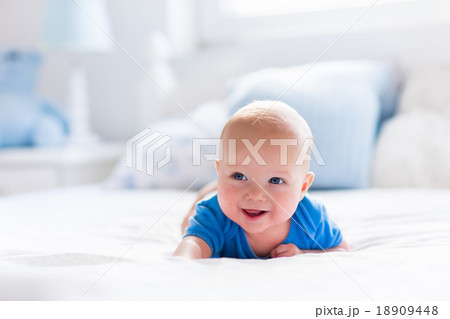 Baby boy in white sunny bedroom 18909448