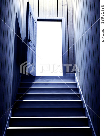 Steps leading from a dark basement to open door 18921339