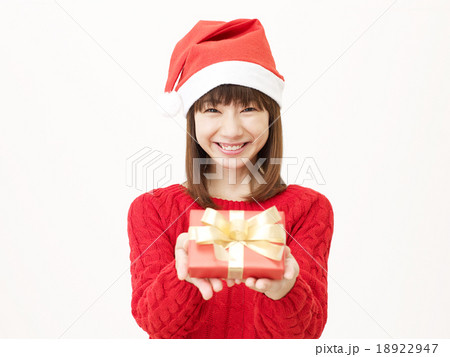 サンタ帽子をかぶる女性 クリスマスプレゼントの写真素材