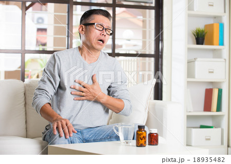 asian senior with stomach pain and medicine 18935482
