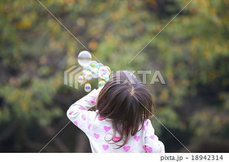 秋の公園でシャボン玉を吹いて遊ぶ女の子の写真素材 18942314 Pixta