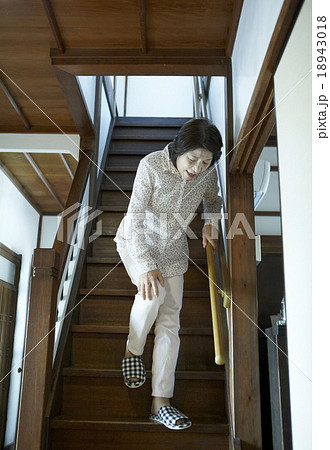 膝痛を堪えて階段を降りるおばちゃん 18943018