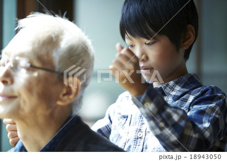 昼下がりにおじいちゃんの肩をたたく孫 18943050